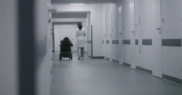Kobieta Lekarz Idzie Korytarzem Kliniki Konsultuje Się Niepełnosprawną Kobietą Lekarz — Zdjęcie stockowe