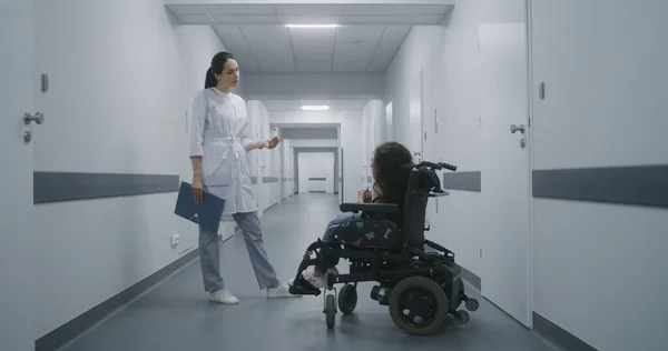 Kadın Doktor Klinik Koridorunda Duruyor Tekerlekli Sandalyede Omurilik Kası Atrofisi — Stok fotoğraf