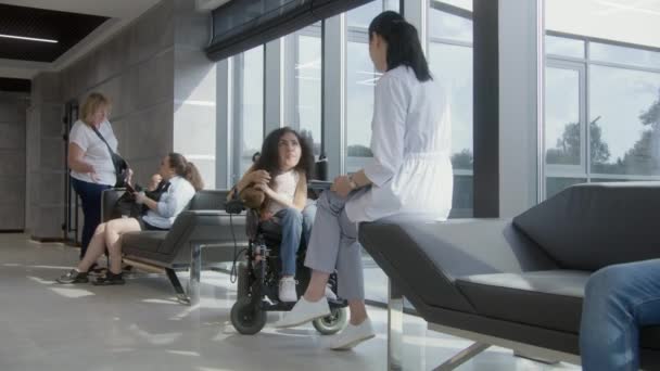 Femme Médecin Consulte Une Femme Handicapée Sma Dans Lobby Hôpital — Video