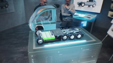İki erkek otomotiv mühendisi, geleceğin sanal gerçeklik holografik modelini kullanarak elektrik motorlu yeni bir çevre dostu kamyon yarattılar. Modern aracın 3 boyutlu bilgisayar grafikleri gelişiyor. VFX canlandırması.