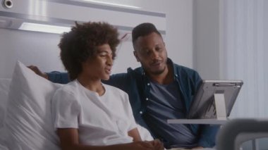 Afro-Amerikalı gençler hastane odasında yatakta dinleniyor. Babam ameliyattan sonra çocuğu ziyaret ediyor. Aile tablet bilgisayar kullanarak uzaktan konuşuyor. Hasta başarılı bir ameliyattan sonra tamamen iyileşiyor. Parlak klinik.