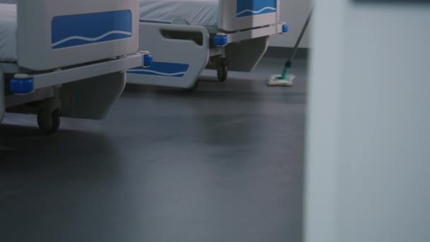 Sluiten Van Volwassen Verpleegkundige Dweilen Vloer Buurt Van Bedden Helder — Stockvideo