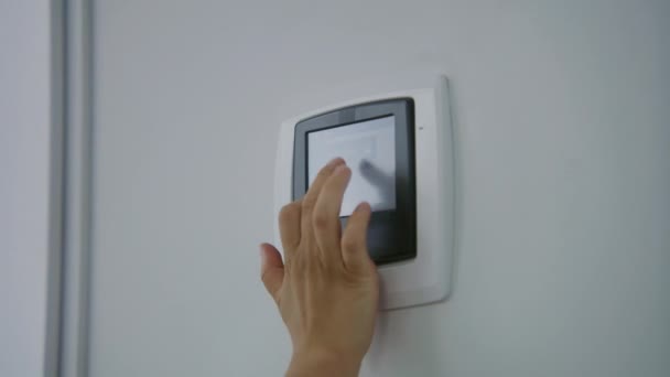 センサーサーサーモスタットまたは圧力コントローラーを使用して 病院の部屋で温度を設定する看護師のクローズアップ 壁に掛かっている電子スマートなモニター クリニックや医療施設の最新設備 — ストック動画