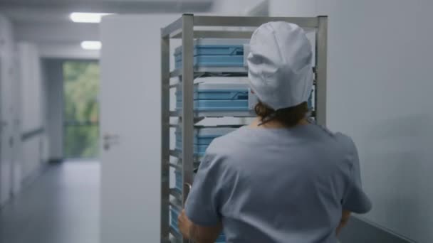 Infirmière Uniforme Déplace Étagères Mobiles Avec Inventaire Dans Couloir Clinique — Video