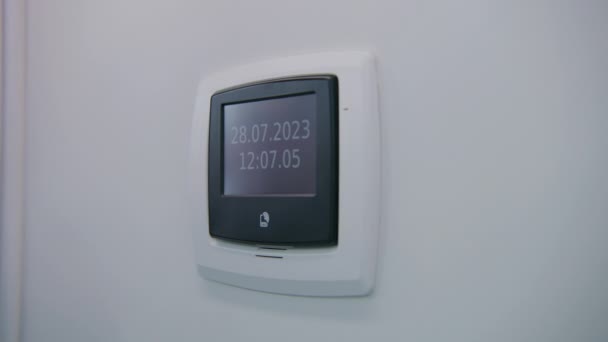 明るい病院区の壁に掛かっている最小限のデザインのデジタルブラックとホワイトクロックのクローズアップショット 電子時計はリアルタイムと日付を示しています 医療施設の最新設備について — ストック動画