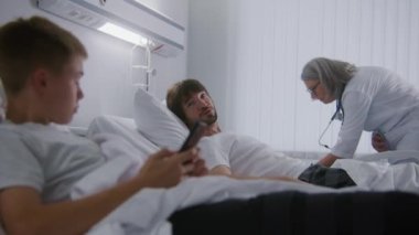 Adam yatakta dinleniyor, küçük çocukla konuşuyor ve televizyonu açıyor. Olgun doktor hastane koğuşundaki hastaları muayene ediyor. Hastane oda arkadaşları başarılı operasyonlardan sonra tamamen iyileşiyorlar. Modern parlak klinik.