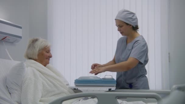 Verpleegster Opent Lunchbox Met Maaltijd Voor Vrouwelijke Oudere Patiënt Oudere — Stockvideo