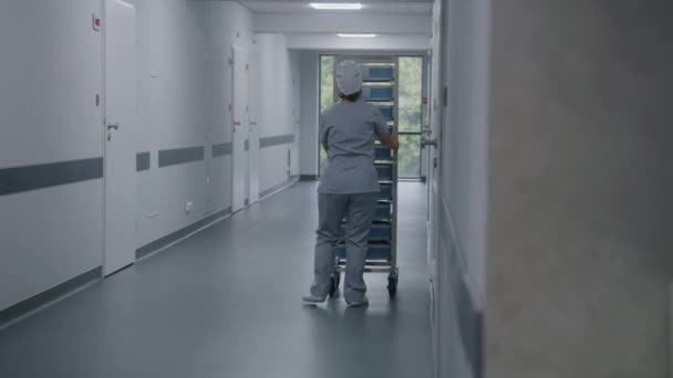 Infirmière Uniforme Pousse Étagères Mobiles Avec Inventaire Travers Couloir Clinique — Video