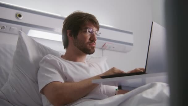 Programmerare Ligger Sängen Sjukhusrummet Och Arbetar Laptop Vuxen Man Spelar — Stockvideo