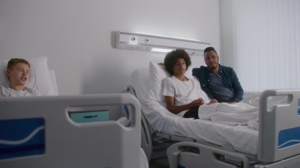 Afroamerikanischer Teenager Liegt Krankenhauszimmer Und Diskutiert Film Mit Vater Der — Stockvideo