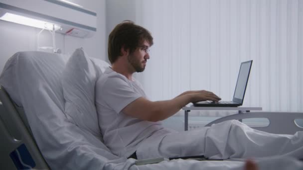Dospělý Muž Leží Lůžku Nemocnici Vzdáleně Pracuje Notebookem Programátor Pracuje — Stock video