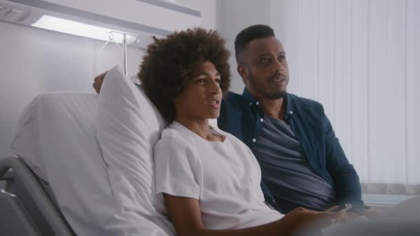 Šťastný Afroamerický Teenager Odpočívá Nemocničním Pokoji Spolu Otcem Dívá Film — Stock video