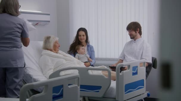 Yaşlı Bir Kadın Ailesi Hastane Odasında Doktor Dijital Tablet Kullanıyor — Stok video