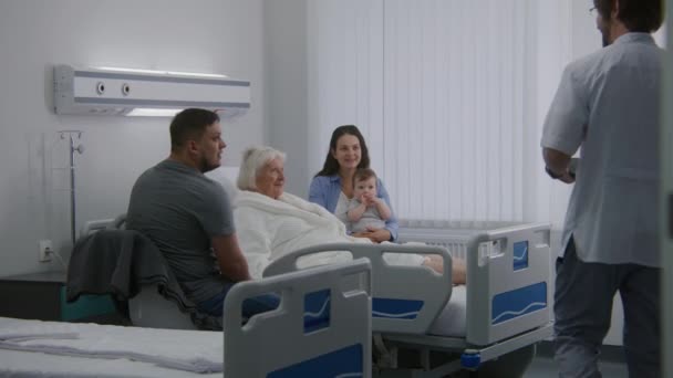 Yaşlı Kadın Hasta Hastane Koğuşunda Yatıyor Ailesiyle Vakit Geçiriyor Doktor — Stok video