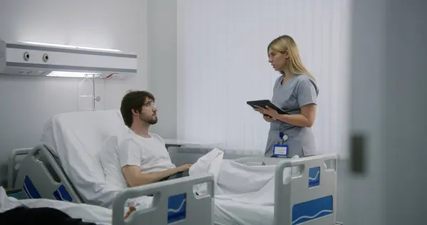 안경을 남자는 병동에서 침대에서 태블릿을 간호사는 환자를 확인하고 테스트 결과를 — 스톡 사진