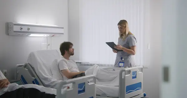 안경을 남자는 병동에서 침대에서 태블릿을 간호사는 환자를 확인하고 테스트 결과를 — 스톡 사진