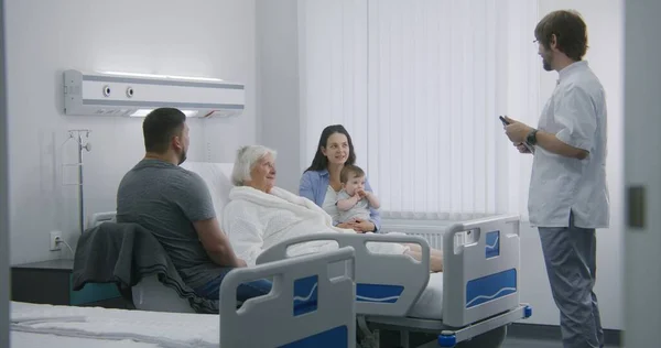 환자는 방에서 침대에 가족과 시간을 보낸다 간호사 의사는 디지털 태블릿을 — 스톡 사진