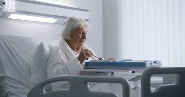 Äldre Kvinna Äter God Mat Och Tittar Kameran Vilar Sängen — Stockfoto