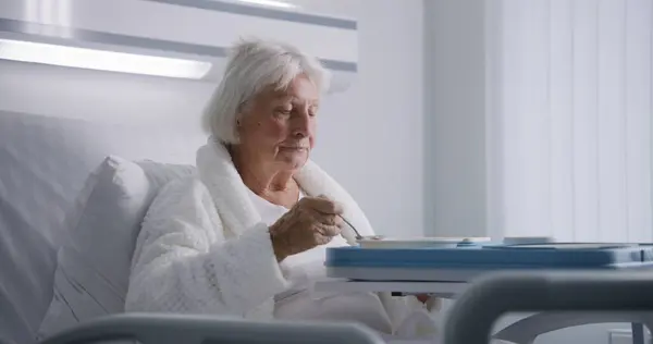 Oudere Vrouw Eet Heerlijk Eten Kijkt Naar Camera Rustend Bed — Stockfoto