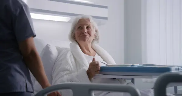 Verpleegster Opent Grote Lunchbox Met Maaltijd Voor Vrouwelijke Oude Patiënt — Stockfoto