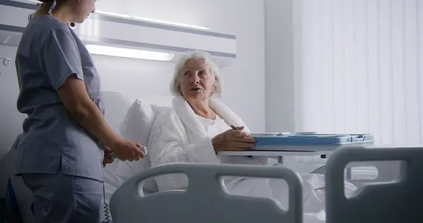 Verpleegster Opent Grote Lunchbox Met Maaltijd Voor Vrouwelijke Oude Patiënt — Stockfoto