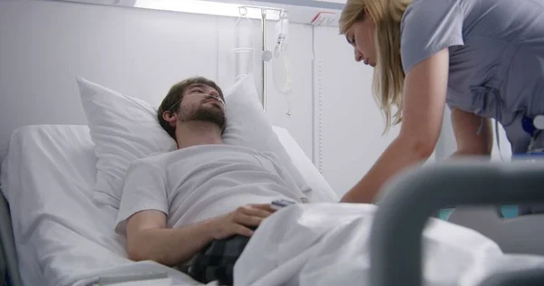 Pielęgniarka Odpoczywa Łóżku Włącza Monitor Tętna Palcu Poprawia Kroplówkę Mężczyzna — Zdjęcie stockowe
