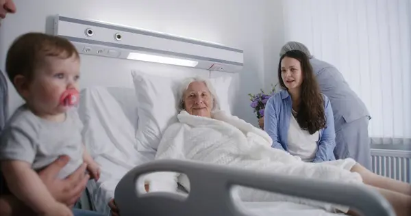 병동에서 침대에서 여자는 손자와 사랑하는 구성원은 성공적인 할머니가 회복을 지원합니다 — 스톡 사진