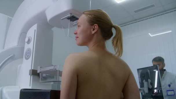 快乐的白人妇女赤身裸体站在诊所放射科病房 在现代医院接受乳房X线摄影扫描检查的女性病人 放射科医生用计算机调整乳房X射线照相机 — 图库视频影像