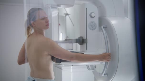 白人成年妇女赤身裸体站在医院放射科病房 采用乳房X线平片机对女性患者进行乳房X线平片检查 乳腺癌的预防 现代诊所设备 — 图库视频影像