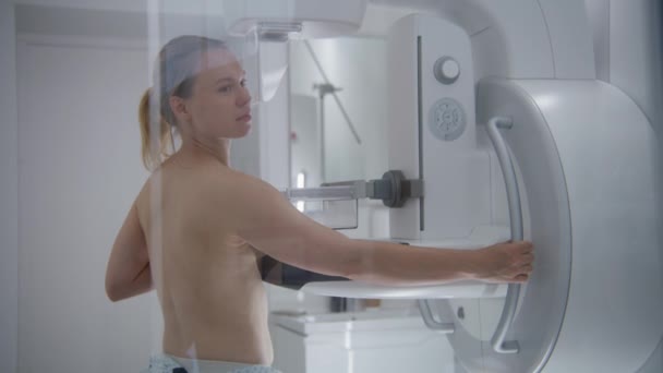 白人成年妇女赤身裸体站在医院放射科病房 使用数字乳房X线摄影检查的女性病人 乳腺癌的预防 现代诊所设备 — 图库视频影像