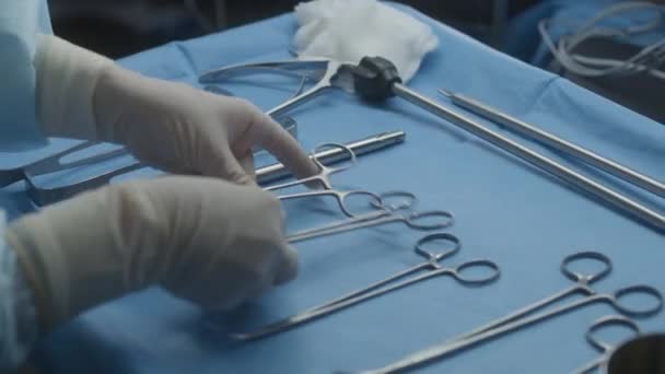 手術のプロの手術器具でテーブルを閉じる 外科医は医療クリップをテーブルの上に置きます 医療スタッフは重傷を負った患者を抱えています 医学は現代の医療施設で働いている — ストック動画