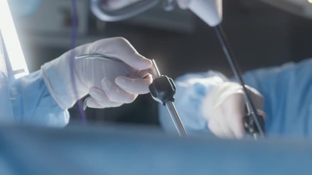 用腹腔镜工具进行手术的专业外科医生的手拉紧 医护人员一起在手术室抢救重伤员 现代医疗设施的医疗工作 — 图库视频影像