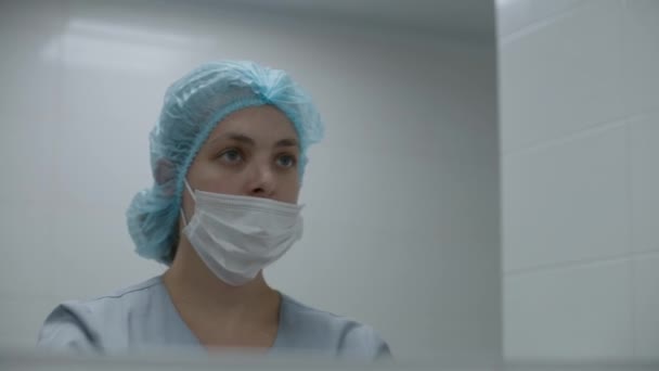 穿制服的护士在手术前洗手 并照镜子 女外科医生准备对严重受伤的病人进行外科手术 现代医疗设施的人员工作 — 图库视频影像