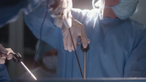 手術中に近代的な機器を使用して男性の医師の閉鎖 制服の専門外科医は 腹腔鏡検査器を使用して病院で患者を操作します オペレーティングルームで働く医療スタッフ — ストック動画