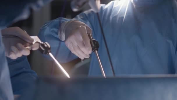 在手术期间使用腹腔镜检查仪器的医疗人员的近视 穿着外科服的专业外科医生使用现代设备进行困难的手术 医护人员在医疗中心拯救生命 — 图库视频影像