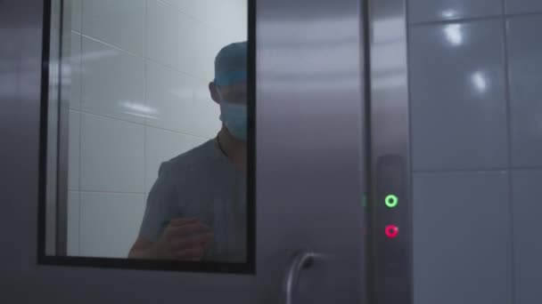 Kirurg Kommer Till Operationssalen Efter Rengöring Händer Och Sätter Labbrock — Stockvideo