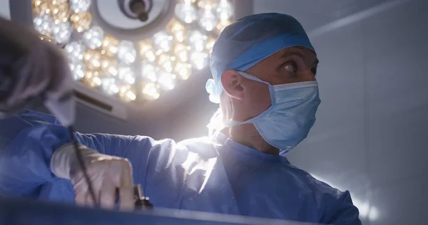 在手术过程中 男性辅助医生的近距离观察 在现代手术室 专业医生使用腹腔镜器械给病人做手术 在医疗中心工作的医务人员 — 图库照片