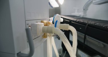 Modern hastanenin ameliyathanesinde ameliyat için gelişmiş ekipmanlarla bekleyen yaşam destek tüplerini ya da akciğer havalandırma makinesini kapatın. Klinikte ya da tıbbi tesiste parlak çalışma bloğu.