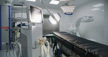 Modern hastanede ameliyat için gelişmiş ekipmanlarla dolu bir ameliyathane. Ameliyat masası, LED lambalar, yaşam desteği ve anestezi makinesi. Klinikte ya da tıbbi tesiste operasyon bloğu.