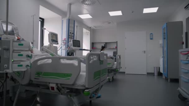 病院に近代的な設備を備えた緊急治療室 酸素マスクの高齢者は 手術が成功した後にベッドで眠る 看護師は医療施設の集中治療部門でコンピュータで働いています — ストック動画