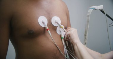 Kalp hastalıkları olan hastaları izlemek için kardiyoloji uzmanına yakın çekim yapıyoruz. Kardiyoloji odasında elektrokardiyografi sırasında Afrikalı Amerikalı bir adam. Hastanede işlevsel rehabilitasyon.