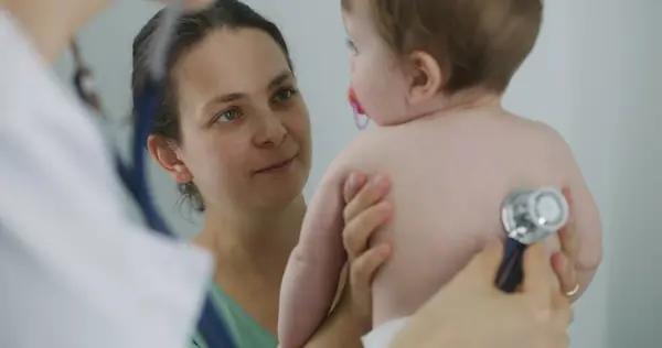 Szczęśliwa Matka Trzyma Rękach Swoje Przystojne Dziecko Smoczkiem Ustach Pediatra — Zdjęcie stockowe