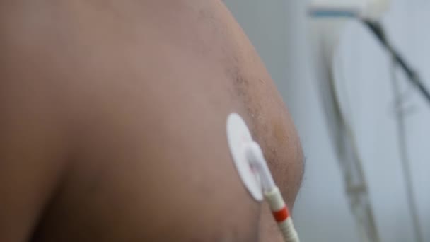 女医生为心脏病患者安装了全息监测传感器 非洲裔美国人在心脏科病房接受功能性康复治疗 现代诊所的心电图 靠近点 — 图库视频影像
