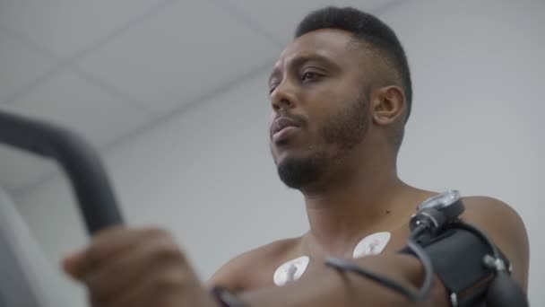 Afrikai Amerikai Férfi Tonométerrel Holter Érzékelőkkel Orbitreket Pedál Kardiológiai Szobában — Stock videók