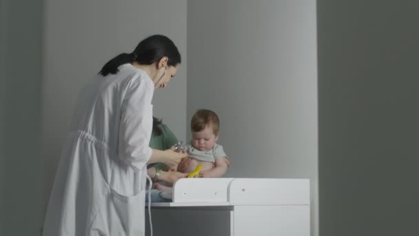 Amigável Pediatra Fêmea Brinquedo Para Bebê Bonito Sentado Mesa Troca — Vídeo de Stock