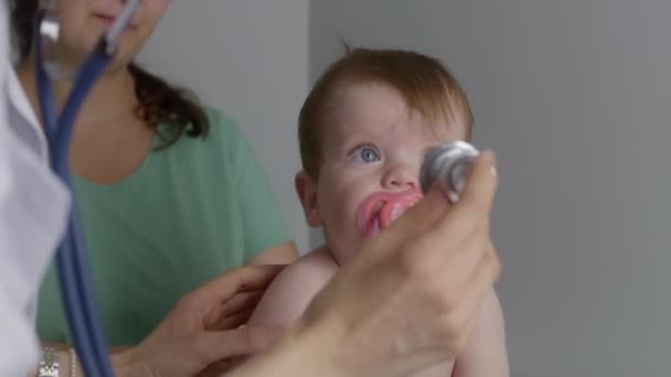Niedliches Baby Sitzt Auf Wickeltisch Nimmt Schnuller Aus Dem Mund — Stockvideo