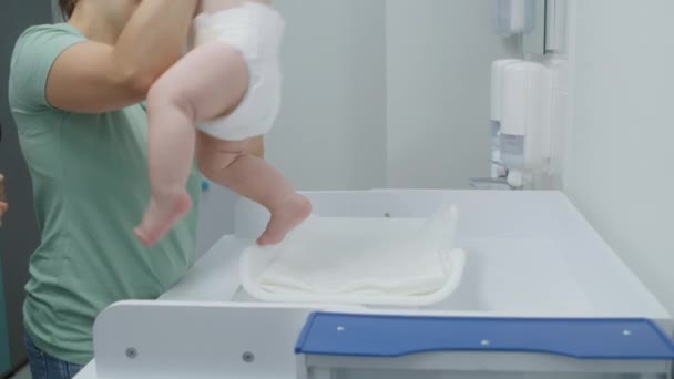 Mulher Segura Criança Coloca Escala Mudar Mesa Médica Pesa Bebé — Vídeo de Stock