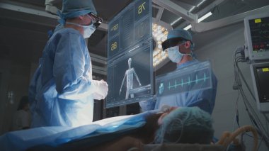 Doktorlar ameliyathanede AR kulaklığı takarak ameliyat yapıyorlar. Sanal yapay zeka hologramının 3 boyutlu grafikleri hayati belirtileri ve hasta durumunu gösteriyor. VFX animasyonu. Modern tıp konsepti.