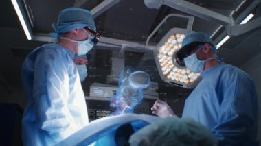 AR kulaklıklı doktorlar modern hastanede ameliyat yapıyorlar. Cerrahlar hastayı insan organlarını ve iskeletini gösteren üç boyutlu sanal hologram kullanarak ameliyat ederler. VFX grafik animasyon. Tıptaki yapay zeka teknolojileri.