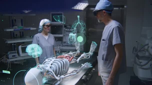 Ar耳机中的男女外科医生使用未来主义全息图在手术室工作 虚拟人体骨骼和器官的三维图形 Ai技术在医学上 保健创新 — 图库视频影像